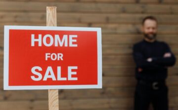 man holding house sign home for sale