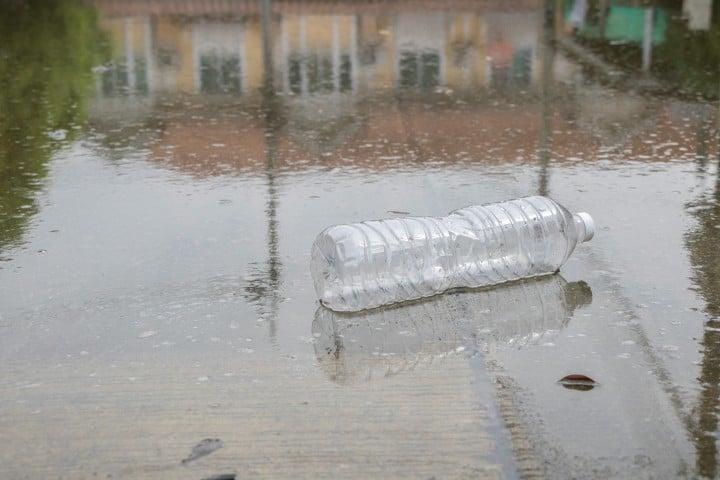 plastic bottle lying in puddle of water