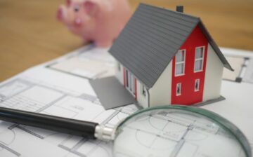 small house with magnifying glass and work papers
