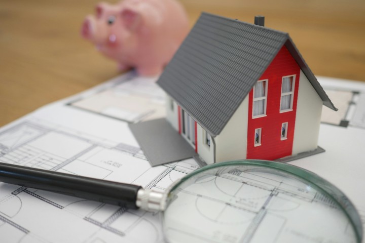 small house with magnifying glass and work papers