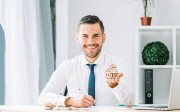 real estate agent with small house in hand