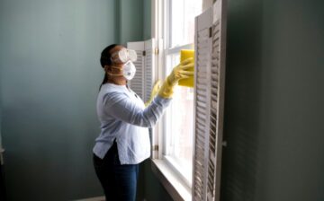woman cleaning window of house for sale