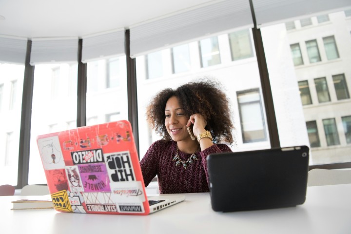 woman talking on cell phone and computer working
