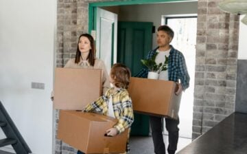 family entering new house with moving boxes