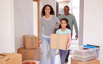 family entering their new house with moving boxes