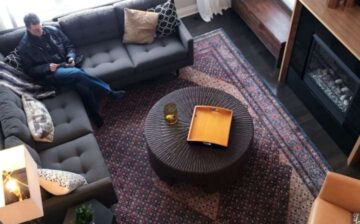 man sitting on his sofa with a large decorative rug