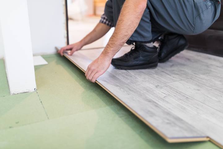 worker processing floor with laminated flooring boards
