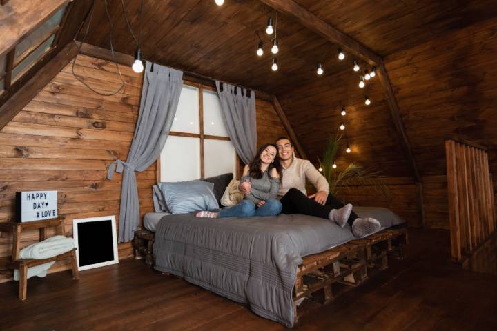 couple in wooden room sitting on bed