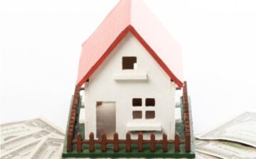 house on scale with bills around
