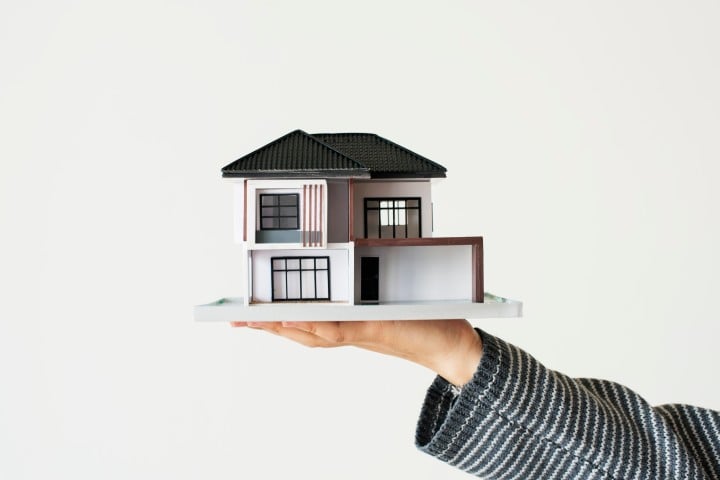 man with house in hand real estate investment