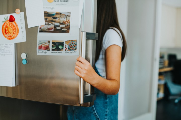 Woman opening the freezer that she is going to prepare for the move