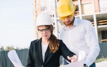 man and woman working in construction looking at blueprint
