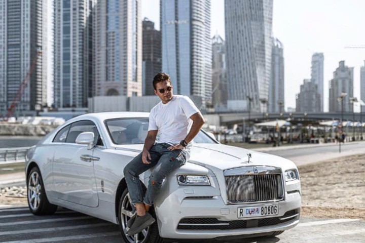 man sitting in a car in dubai city