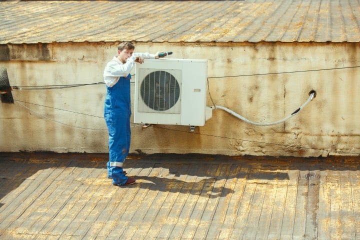 man working on replacing an air conditioner