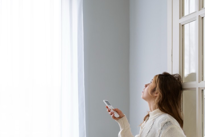 woman setting the temperature in the air