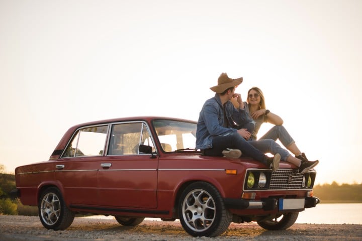 young couple sitting classic car