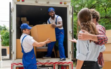 Couple watching their moving boxes being unloaded