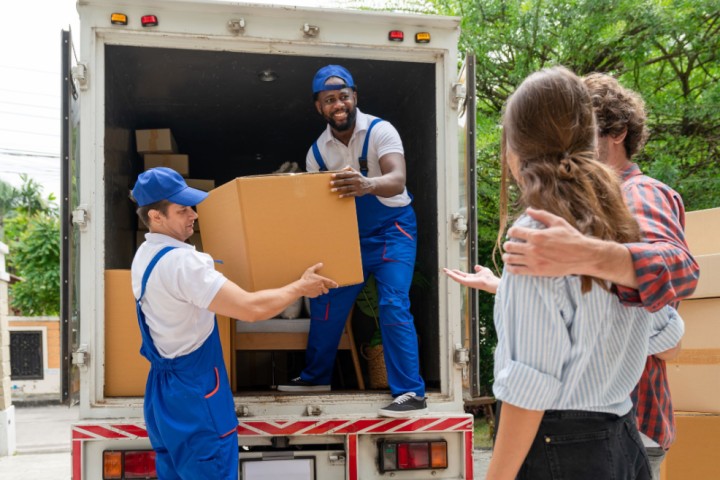 Couple watching their moving boxes being unloaded
