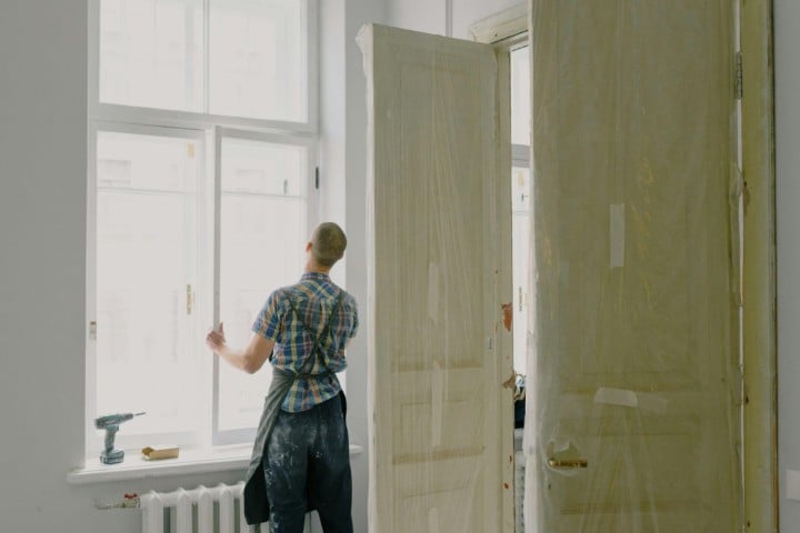 man placing window in room
