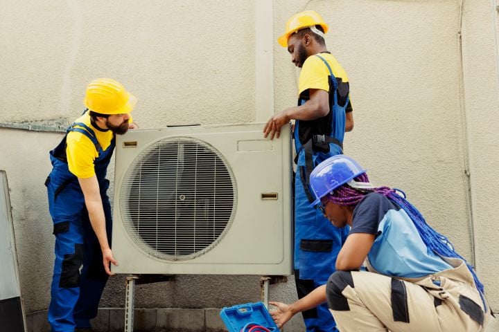 team replacing old air conditioner