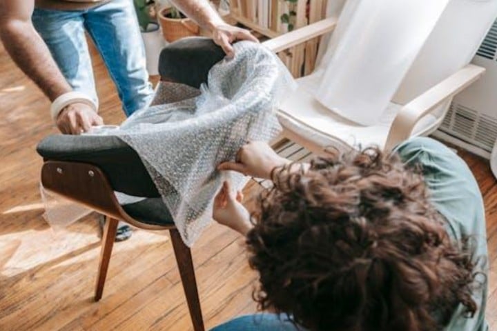 couple protecting a sillon with plastic