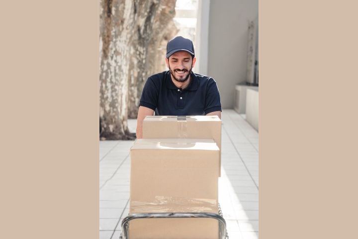 delivery smiling man with cardboard boxes