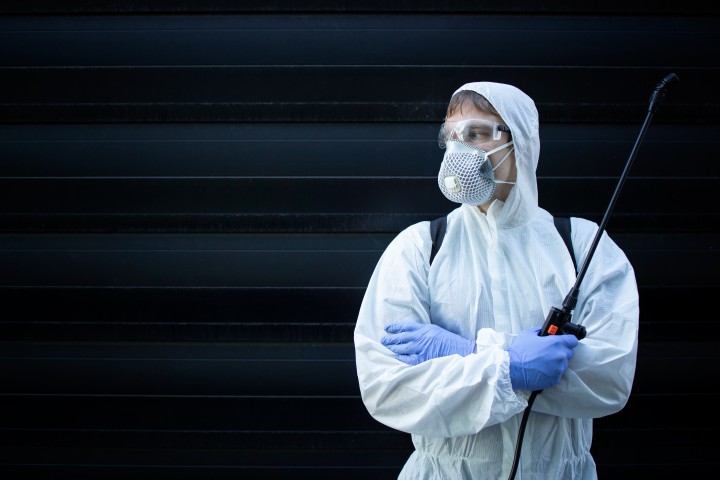 professional exterminator holding sprayer with chemicals pest control