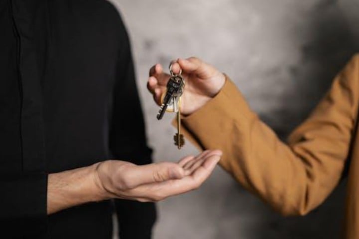 woman handing over house key