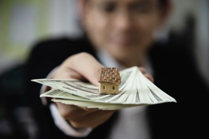 woman with money in hand and home