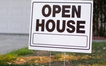 Open house sign in the yard of a house for sale