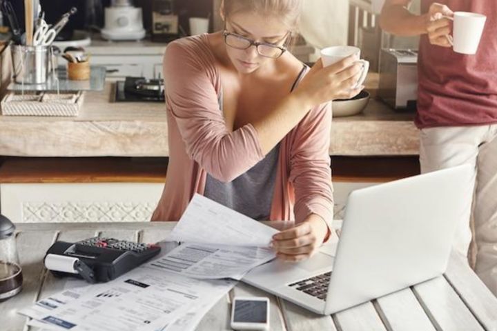 woman at computer looking at papers