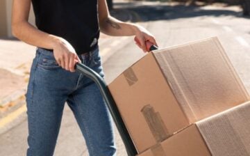 woman with moving dolly and moving boxes