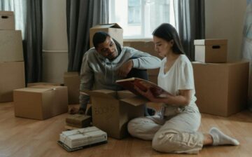 couple looking at album between moving boxes
