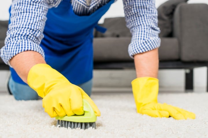 man cleaning his rug