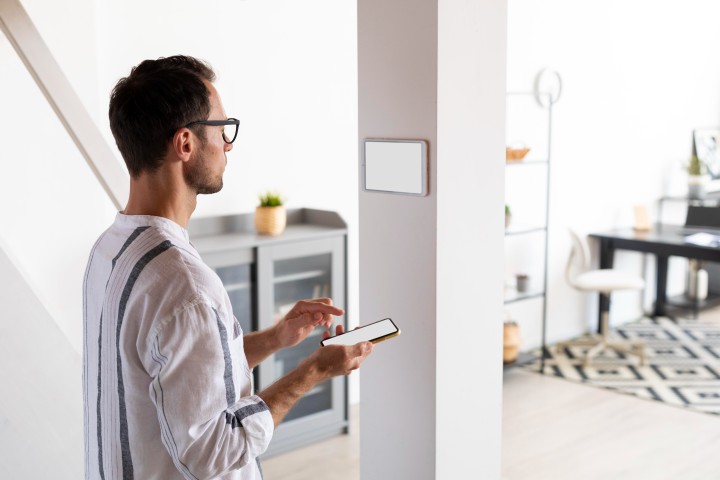 man using smartphone his automated home