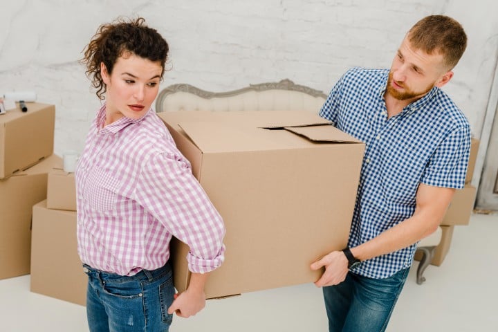 man woman carrying big box