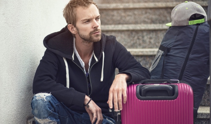 a person seating on a staircase with a suitcase
