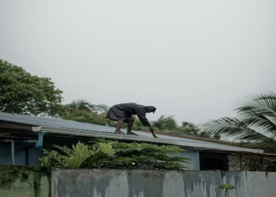 person is cleaning a gutter