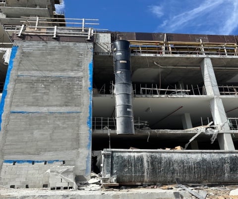 Heavy duty debris chutes for demolition installed on a multi-story construction site facilitating safe and efficient debris removal