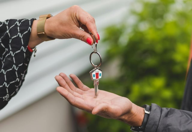 female hands a house key