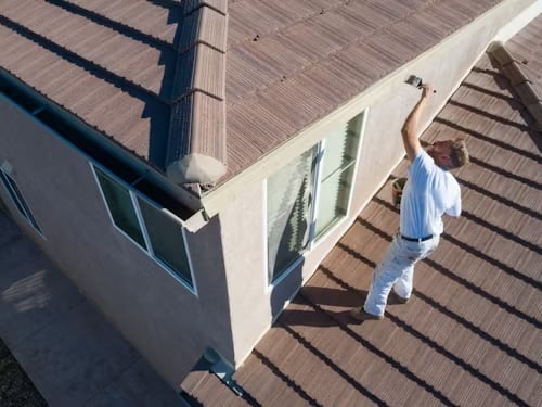 painter painting exterior of a home