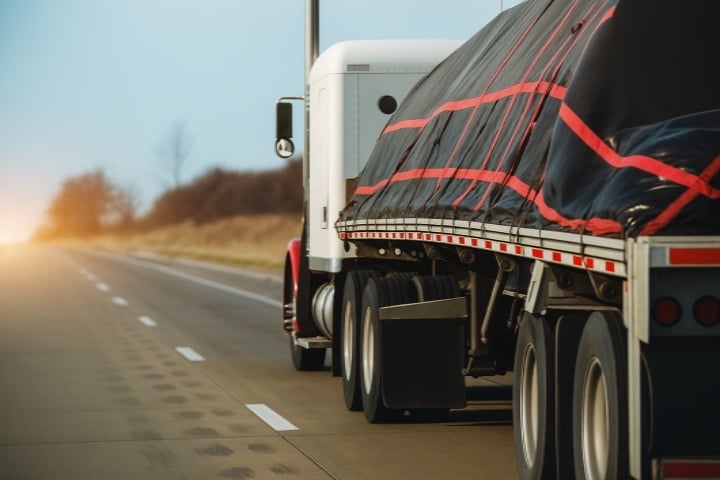 Flatbed truck hauling load.